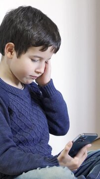 Portrait of a young boy using an app on a digital tablet at home at nighttime with headache