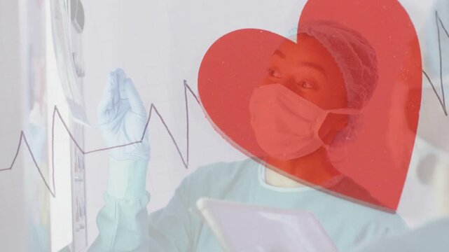 Clinician pointing screen holding tablet raising gloved hand checking vitals with ECG heart overlay