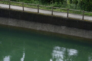 Naklejka premium Calm Canal with Green Water and Concrete Embankment 