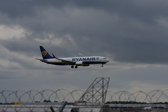 Ferno, Italy - May 15, 2026: Passenger airplane taxiing at Milan Malpensa Airport with control tower and runway under cloudy sky