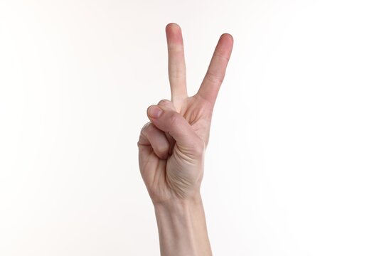 Woman showing number two with fingers on white background, closeup