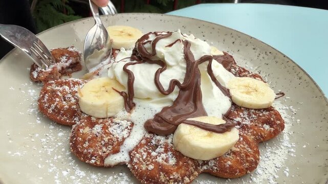 Eating banana waffle with chocolate sauce