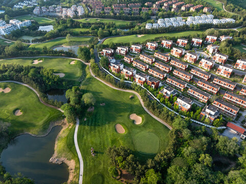 Aerial view of a residential community with townhouses adjacent to a well-maintained golf course
