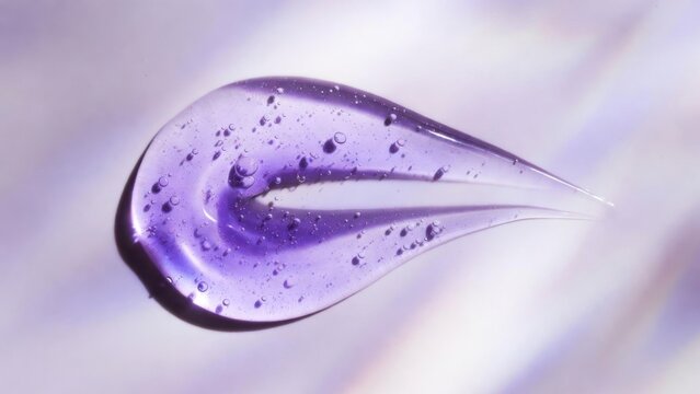 Purple gel droplet suspended in soft blurred background closeup
