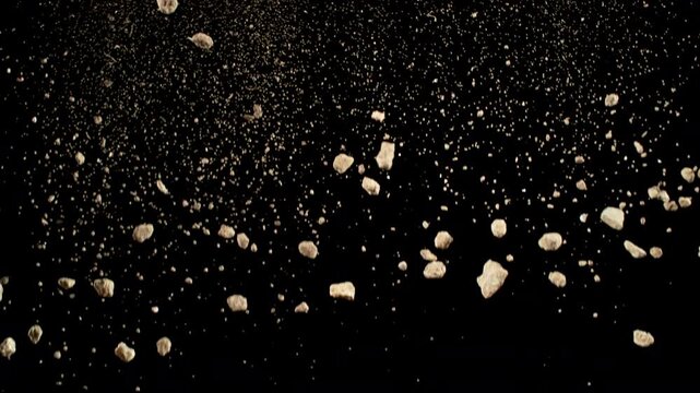 Super Slow Motion Shot of Falling Soil with Rocks on Black Background at 1000fps.