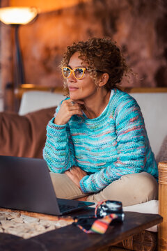Woman focusing and thinking while working remotely on her laptop with glasses, networking and telecommuting from a comfortable home office or co-working space