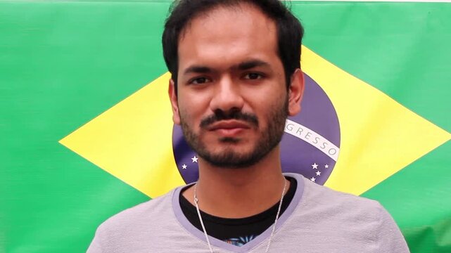 Young man eating traditional Lebanese and Syrian kofta kebab in front of Brazilian flag, authentic Middle Eastern grilled meat cuisine concept with cultural fusion and international gastronomy theme