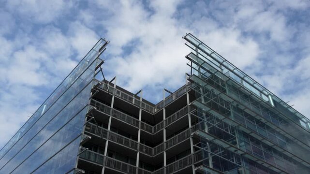 Timelapse footage showing fast-moving clouds passing over Sanomaa House in Helsinki, Finland. The cinematic sky motion highlights changing light and weather over the modern city.