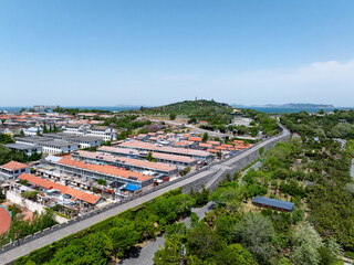 Fototapeta premium Aerial view of Penglai Pavilion scenic area with ancient city wall and coastal landscape