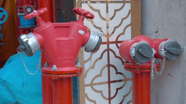 A close-up of a red fire hydrants standing on the sidewalk in Da Lat City, Vietnam