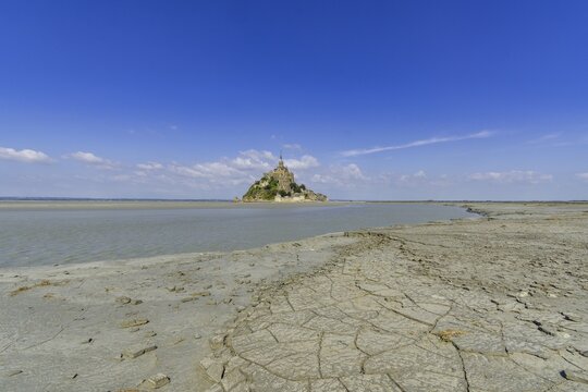 View over dried mud at the edge of the salt marshes at low tide on Mont-Saint-Michel, D&eacute;partement Ille-et-Vilaine, France