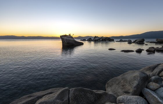 Lake shore, Bonsai Rock, small tree on a rock in the water at sunset, Lake Tahoe, California, USA