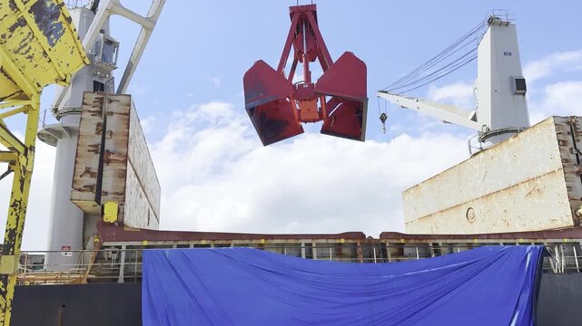 crane operator put open grab from ship and place to the berth