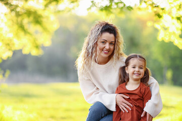Naklejka premium Mother with her cute little daughter in nature on sunny day. Space for text