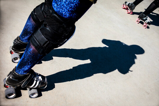 Roller skater casting a strong shadow on concrete
