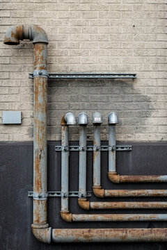 Industrial pipes on a weathered brick wall
