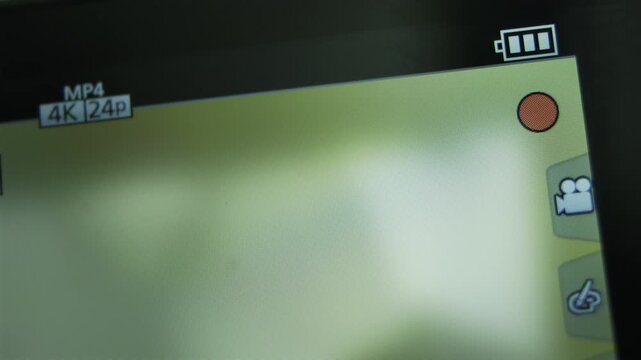 Recording video on camera display. Camera screen macro shot showing recording format and battery status