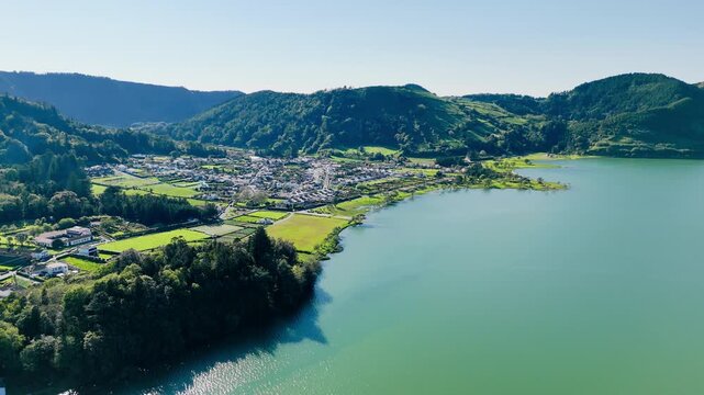 Aerial footage of volcanic crater lake Lagoa Azul with calm water, Sao Miguel Island