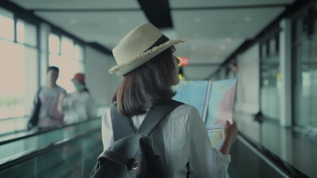 Holiday concept of 4k Resolution. Asian woman looking at map, she is planning her trip while inside the terminal building.