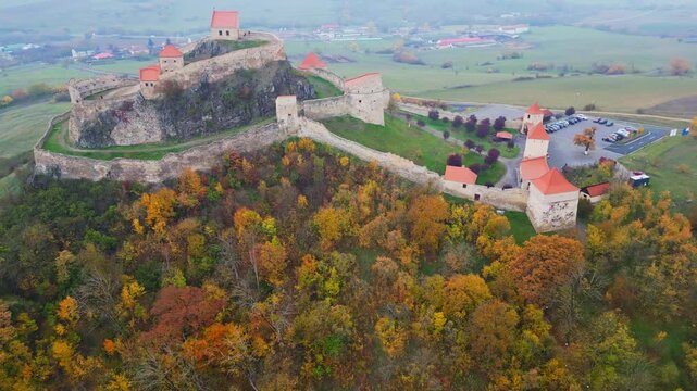 High angle view of the restored Rupea medieval citadel built on a basalt rock in Brasov, Transylvania. Spectacular historic Saxon fortress in a scenic Romanian rural landscape.