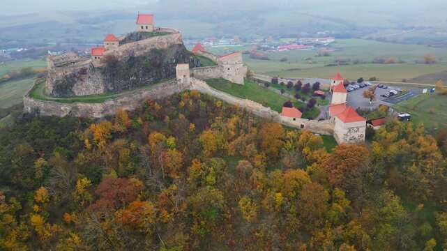High angle view of the restored Rupea medieval citadel built on a basalt rock in Brasov, Transylvania. Spectacular historic Saxon fortress in a scenic Romanian rural landscape.