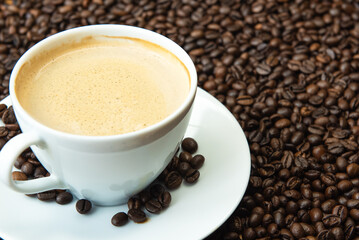 Obraz premium Premium dark roast arabica coffee beans with cozy cup of warm steaming coffee with late art
