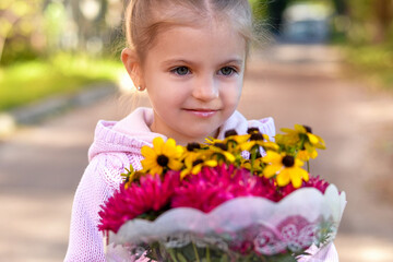 Fototapeta premium ​Close-up of a child holding a bouquet for the teacher on Knowledge Day.