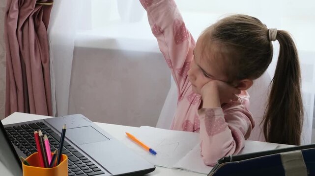 Hybrid learning child studying with laptop and notebook at home