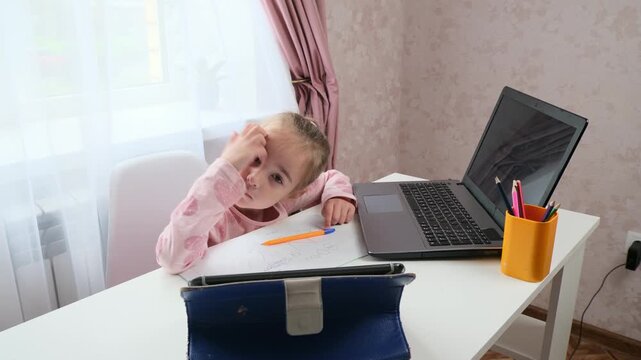 Hybrid learning child studying at home with laptop and focus