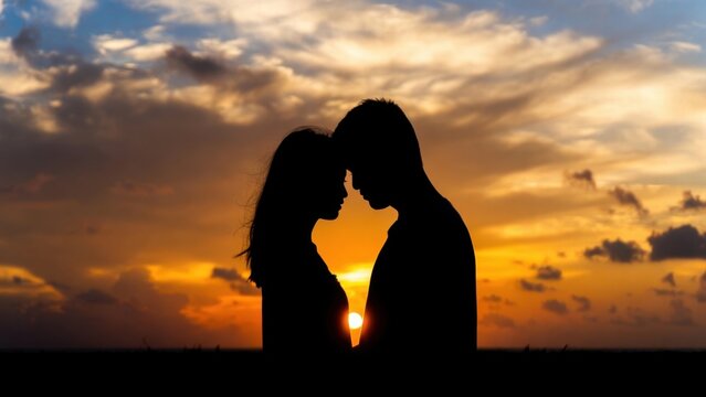 Couple facing each other at sunset on coastal horizon