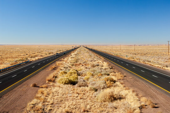 People traveling long, straight stretch of Interstate 40 in the vast desert of Arizona, Southwest USA