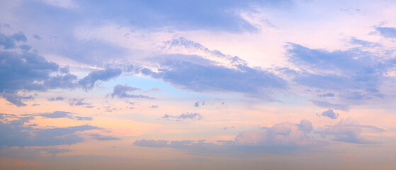 Fototapeta premium A wide panorama of a beautiful pink and blue sunset sky with clouds. The sky in pink and blue tones creates an atmosphere of calm and tranquility.