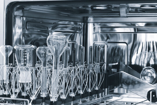 Laboratory chemical glass after washing in a special washing machine with the door open.