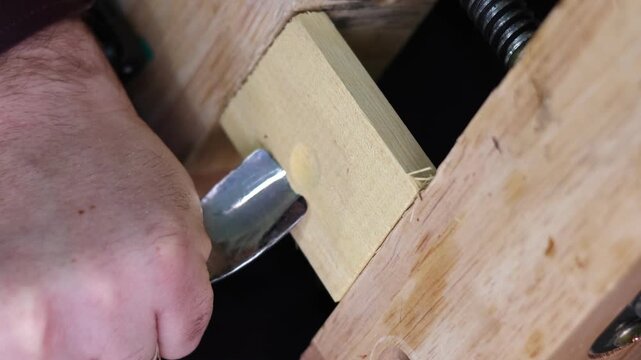 carpenter cutting wood with chisel