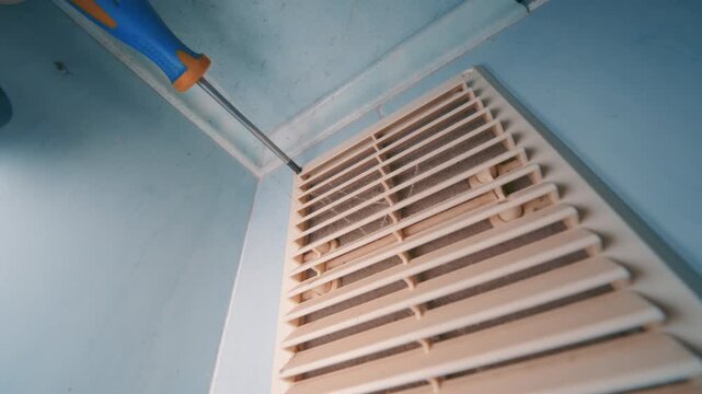 Dirty Ventilation Grille Removal with Screwdriver | Bottom-Up Wide-Angle View of HVAC Maintenance Handheld | Dusty Air Vent Disassembly Indoor