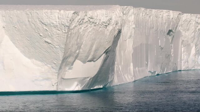 Huge chunk of ice breaking off an arctic glacier and collapsing into the cold polar ocean