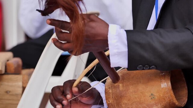 An African person playing a typical instrument from their African country at a party