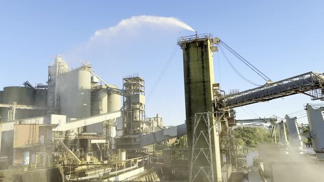 port grain terminal load wheat to the bulk carrier ship. clouds of grain dust on air. terminal tower spray water, make industrial waterfall for dust suppression