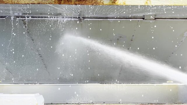 team of seafarers wash hatch covers of ship cargo holds. water jet remove dust and cargo residues. team work. seaman job and life. 