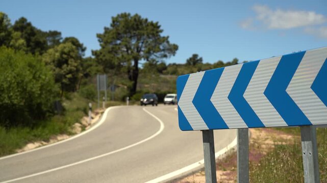 Detalle de una se&ntilde;al de tr&aacute;fico de peligro que avisa de la proximidad de una curva en una carretera comarcal de Madrid, Espa&ntilde;a. Mayo de 2026.