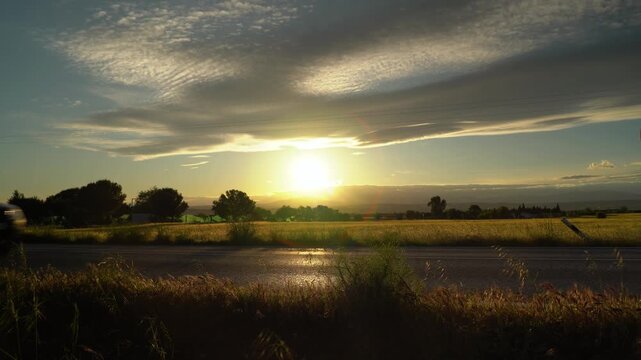 Atardecer en una carretera comarcal de Madrid, Espa&ntilde;a, con unos coches circulando. Mayo de 2026.