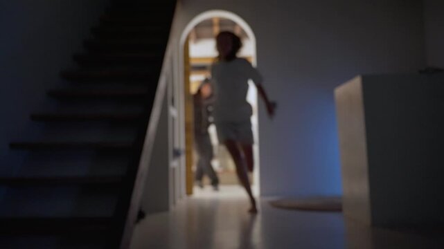 Woman escaping a chasing man in a dark house at night