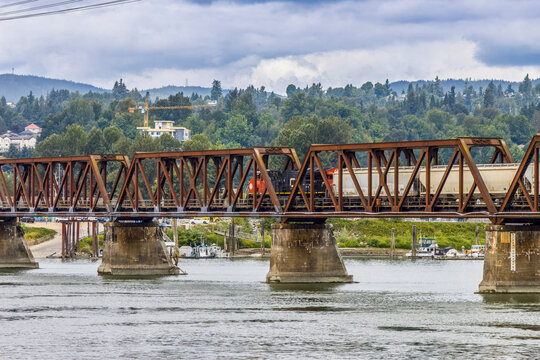 train engine crossing the Fraser River on an old bridge