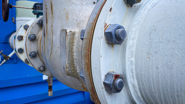 Close up of stud bolt and nut connect two pipe flanges in an industrial plant, symbolizing engineering design, strength,