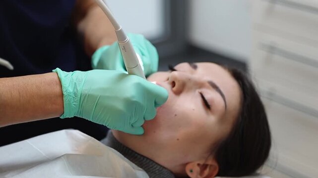 A dentist treats the teeth of a young patient in a dental clinic.