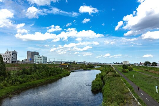 豊平川の流れと新緑の河川敷サイクリングロード

