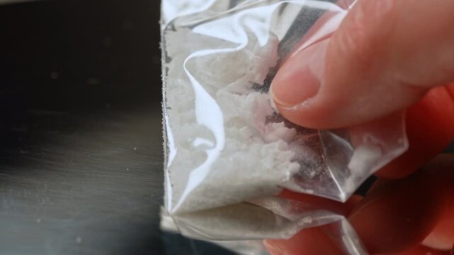 Synthetic opioids crystals like fentanyl or nitazenes drugs in the plastic bag. Opioids account for two thirds of drug overdose deaths worldwide. Extremely potent drugs in the hands of the drug user.