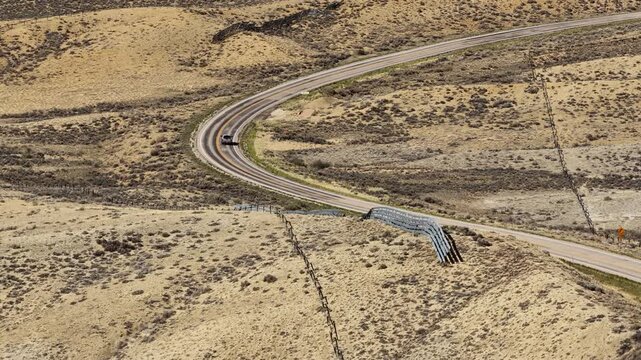 Aerial of truck driving through northeast Utah desert low rolling hills near Vernal