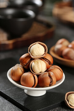 Fresh Hazelnuts Cracked Open Showing White Kernels on Ceramic Stand