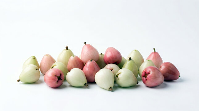 A pile of fresh pale pink, white, and light green water apples known as Chempottikka in Kerala, isolated on a white background. Nostalgic South Indian childhood bell fruit.